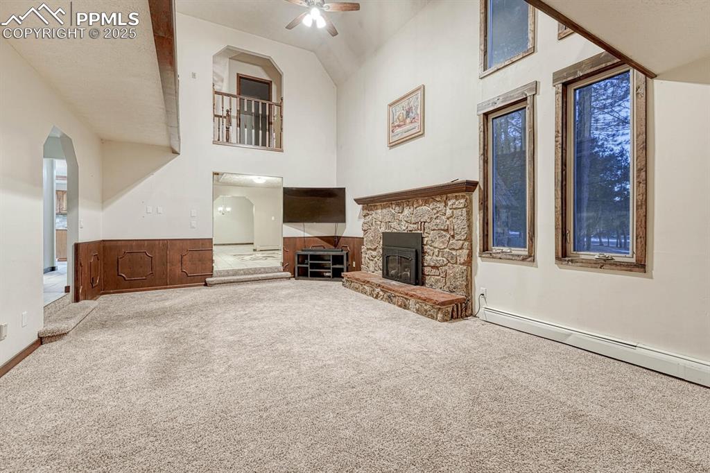 Image 14 of 47: Unfurnished living room featuring a baseboard heating unit, a fireplace, a