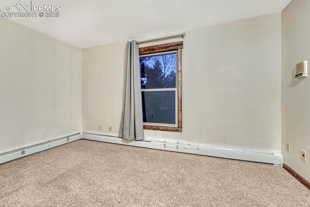 Image 21 of 47: Spare room with a textured ceiling and carpet