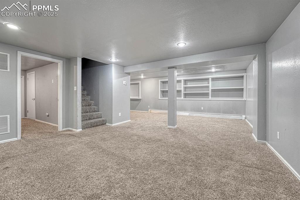 Image 28 of 47: Finished below grade area featuring a textured ceiling, visible vents, carp