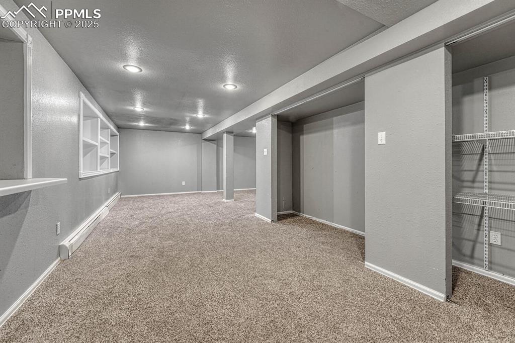 Image 30 of 47: Finished below grade area with a baseboard radiator, carpet flooring, baseb