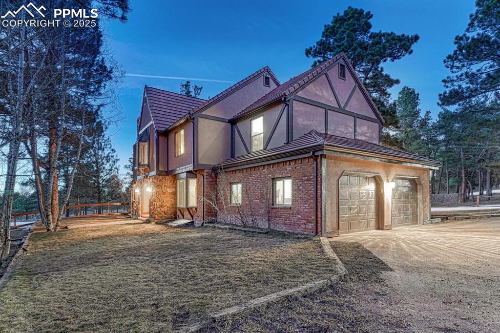 Image 4 of 47: View of side of home featuring stucco siding, driveway, an attached garage,