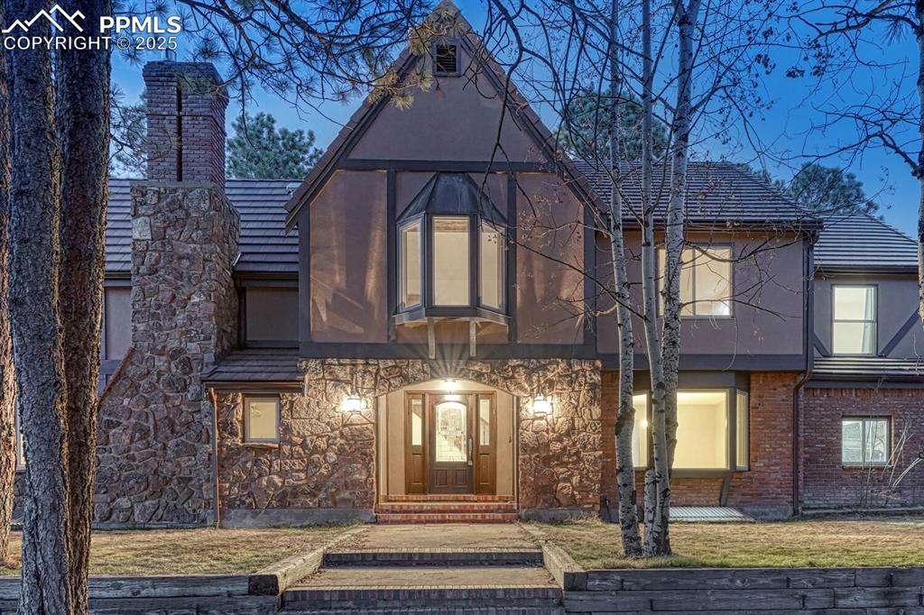 Image 5 of 47: View of front of property featuring a front yard, a chimney, and stucco sid