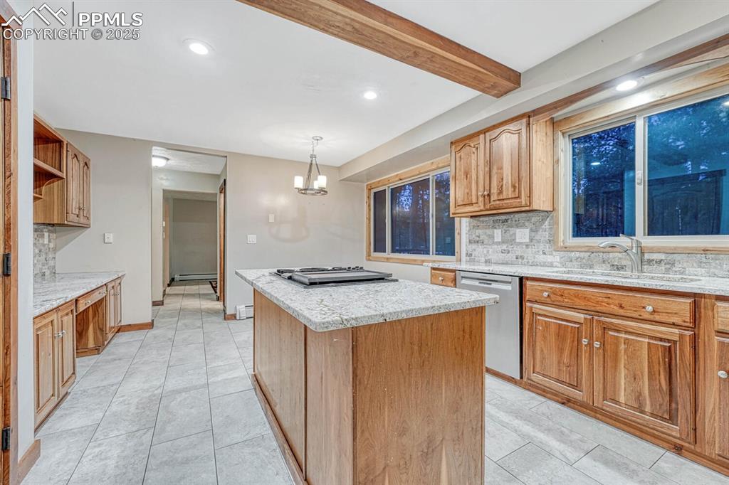 Image 9 of 47: Kitchen with a center island, a sink, backsplash, stainless steel dishwashe