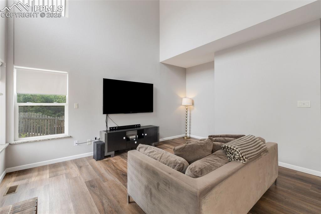 Image 15 of 41: Living room with a towering ceiling and wood finished floors