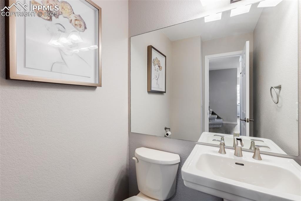 Image 16 of 41: Half bath featuring a textured wall and toilet