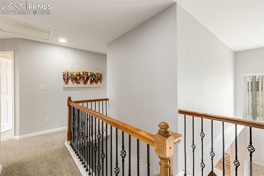 Image 17 of 41: Hallway with an upstairs landing, attic access, carpet flooring, and recess