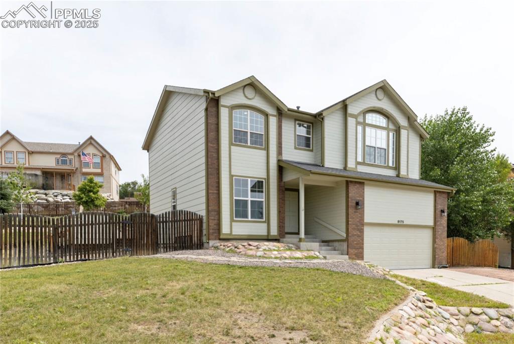 Image 2 of 41: View of front of home featuring brick siding, concrete driveway, a garage, 
