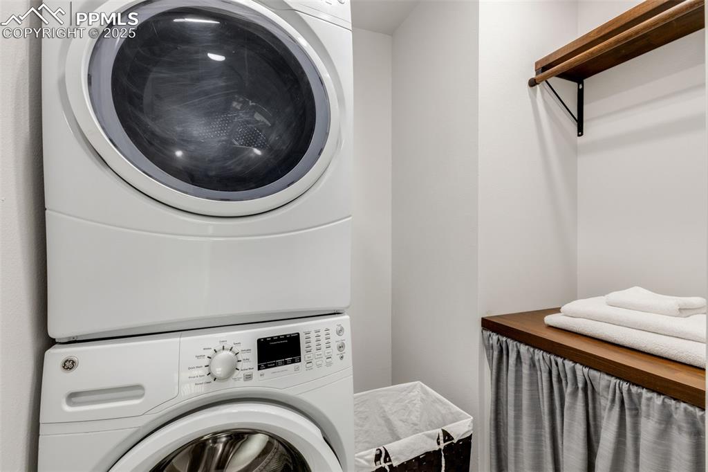 Image 27 of 41: Washroom featuring stacked washer and clothes dryer