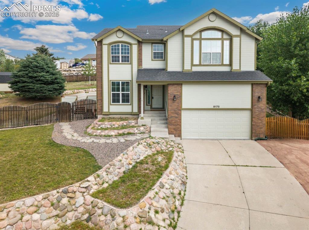 Image 3 of 41: View of front of property featuring concrete driveway, brick siding, a gara