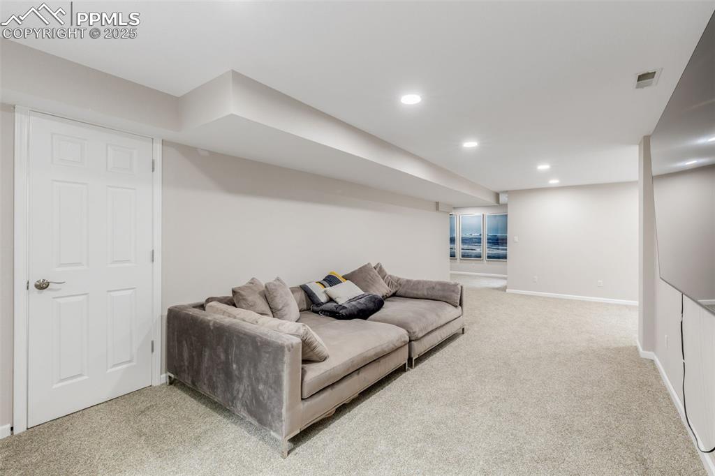 Image 30 of 41: Living room with light carpet and recessed lighting
