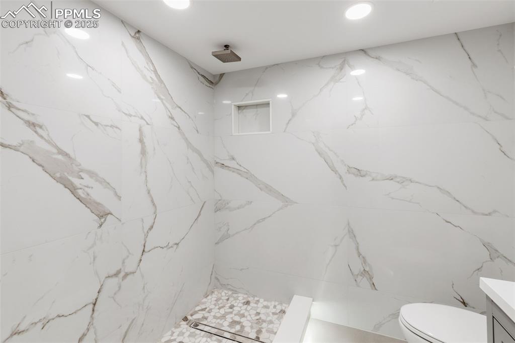 Image 33 of 41: Bathroom featuring a marble finish shower, vanity, and recessed lighting
