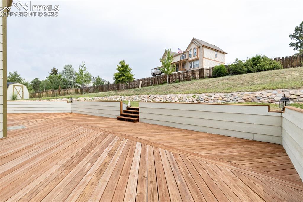 Image 34 of 41: Deck with a fenced backyard and a storage shed