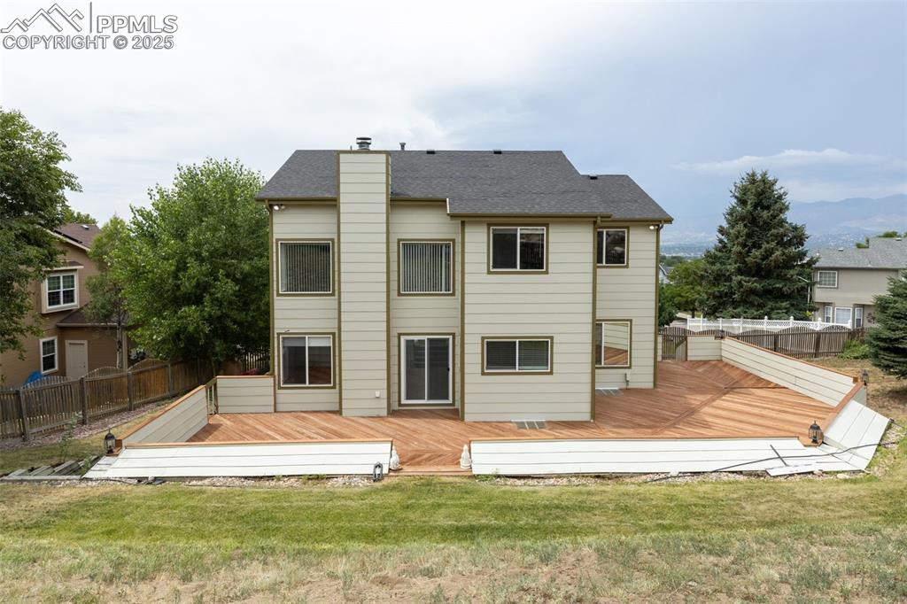 Image 36 of 41: Back of property with a deck, a chimney, and a shingled roof
