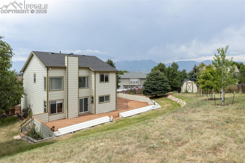 Image 37 of 41: Rear view of property featuring a storage unit, a deck with mountain view, 