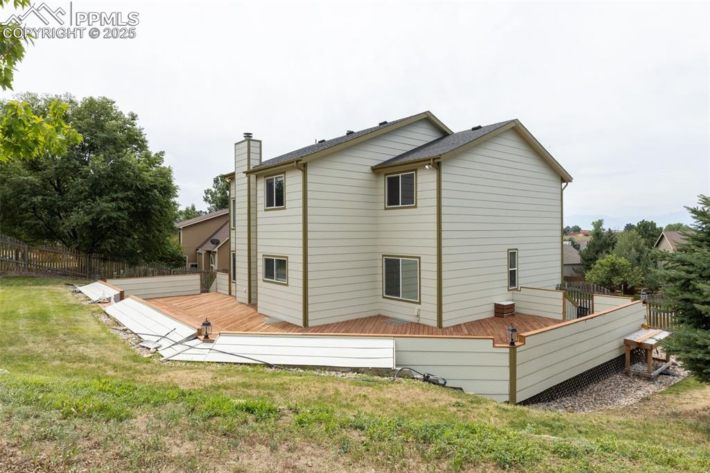 Image 38 of 41: Rear view of property with a wooden deck and a chimney