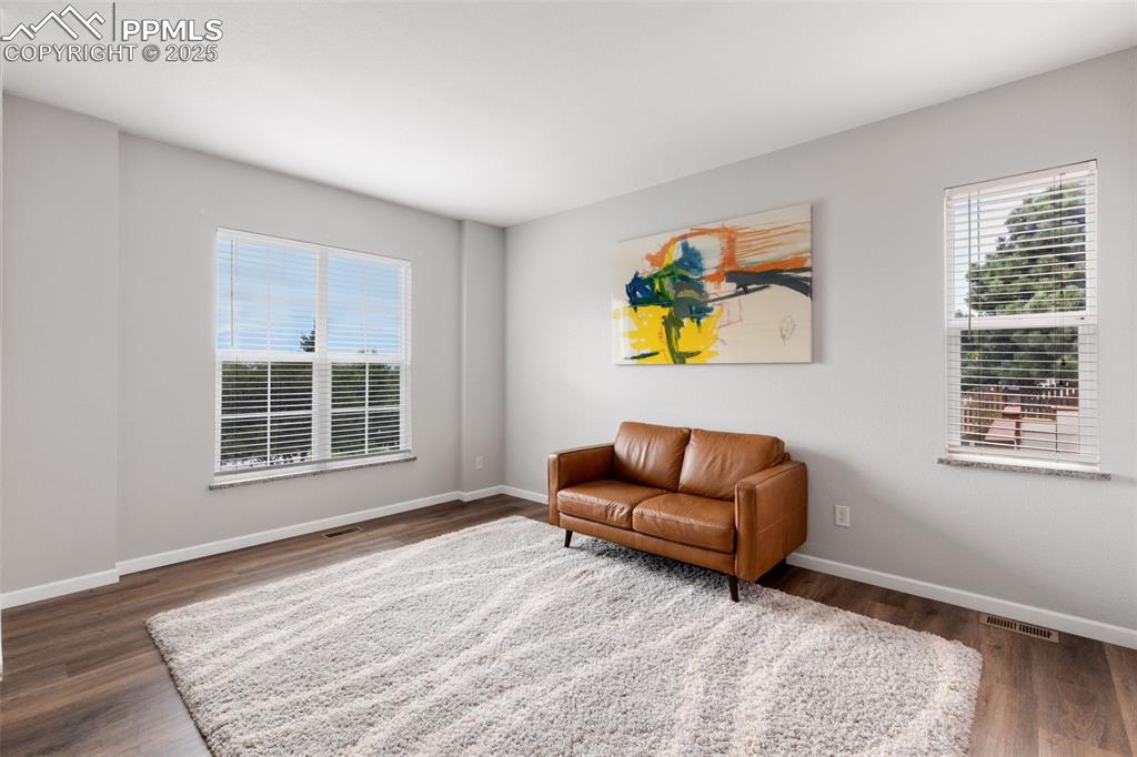 Image 8 of 41: Sitting room with wood finished floors and baseboards