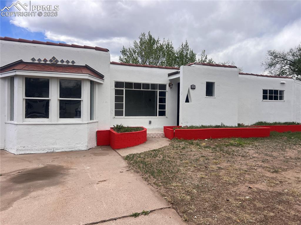 Image 18 of 21: White stucco exterior featuring a red tile roof and contrasting red-painted