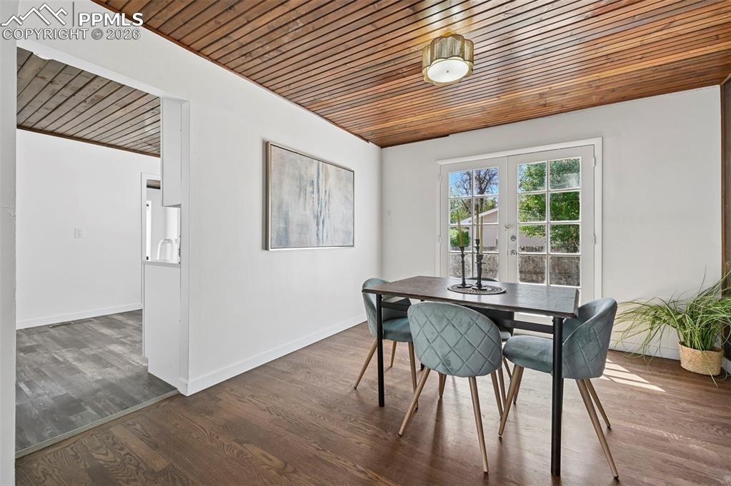 Image 5 of 21: Dining area featuring a wood ceiling, dark wood-finished flooring. 