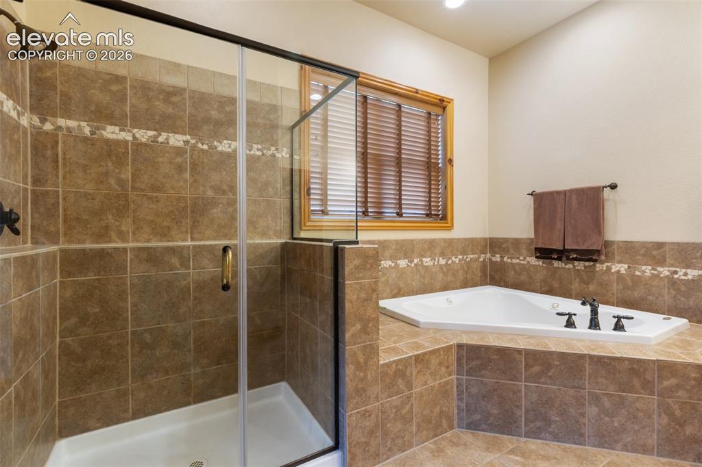 Image 21 of 50: Primary bathroom has jetted tub, double vanity, convenient linen closet and