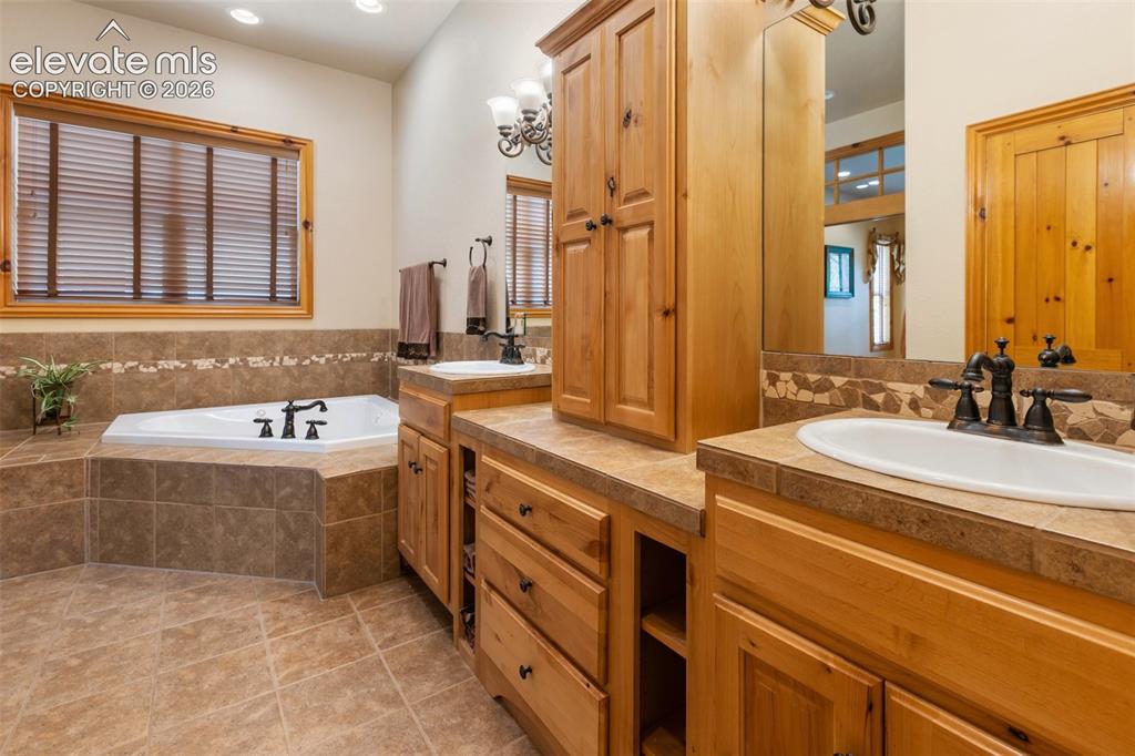Image 22 of 50: Primary bathroom has jetted tub, double vanity, convenient linen closet and
