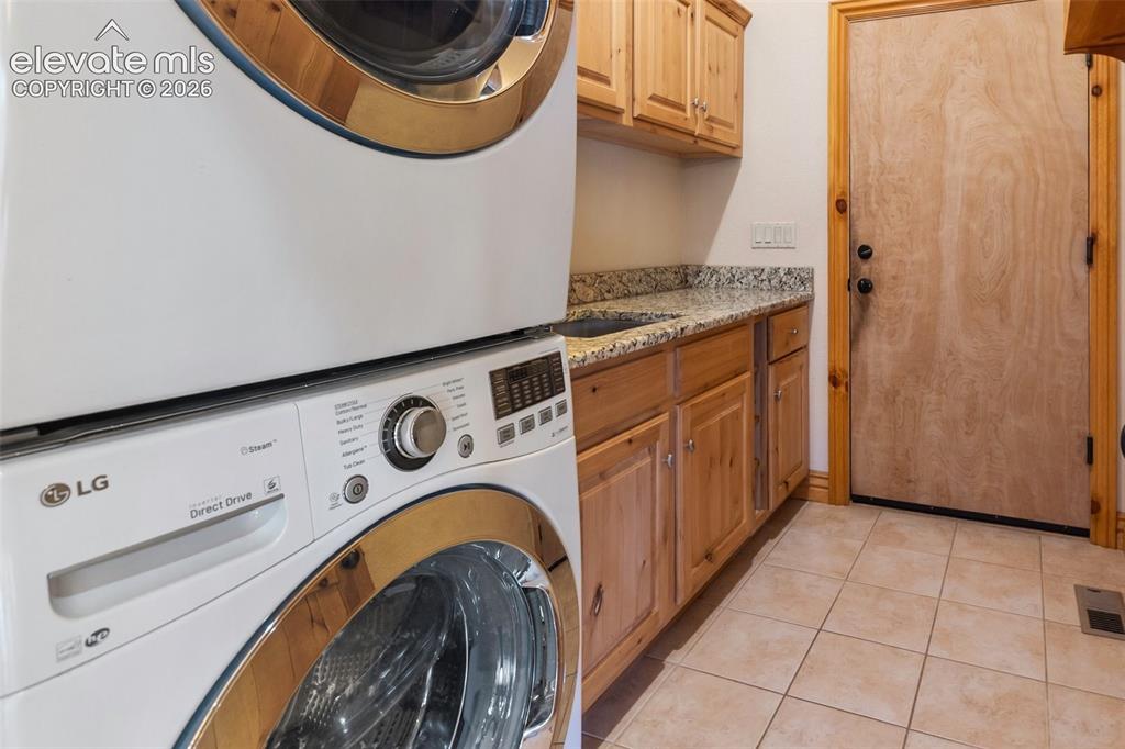 Image 23 of 50: Stackable washer & dryer is included, and the laundry room has sink, storag