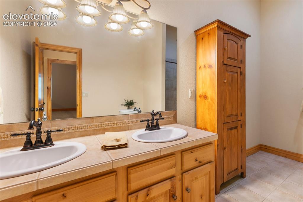 Image 37 of 50: Lower level oversized bathroom with double vanities.