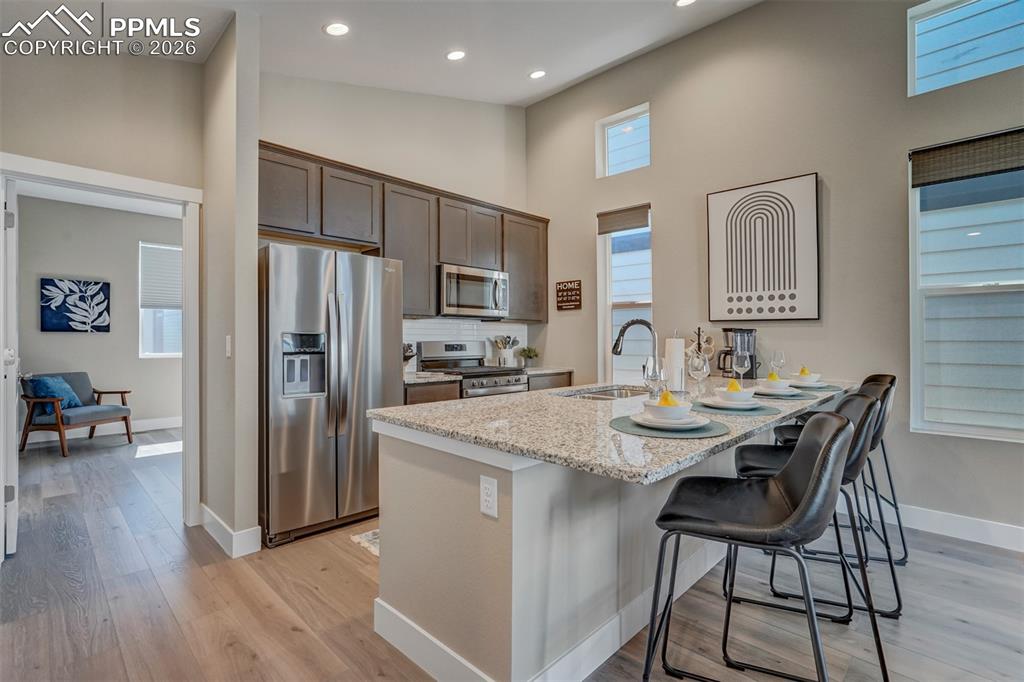 Image 18 of 46: Kitchen featuring stainless steel appliances, light stone counters, a break