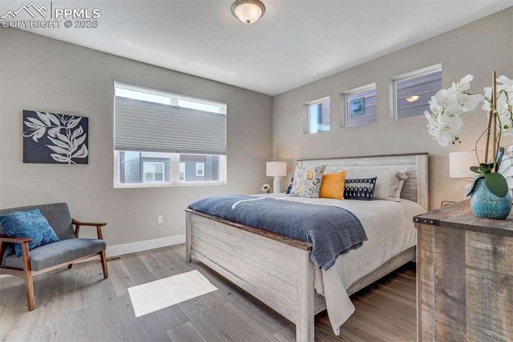 Image 23 of 46: Bedroom with light wood-style floors and baseboards
