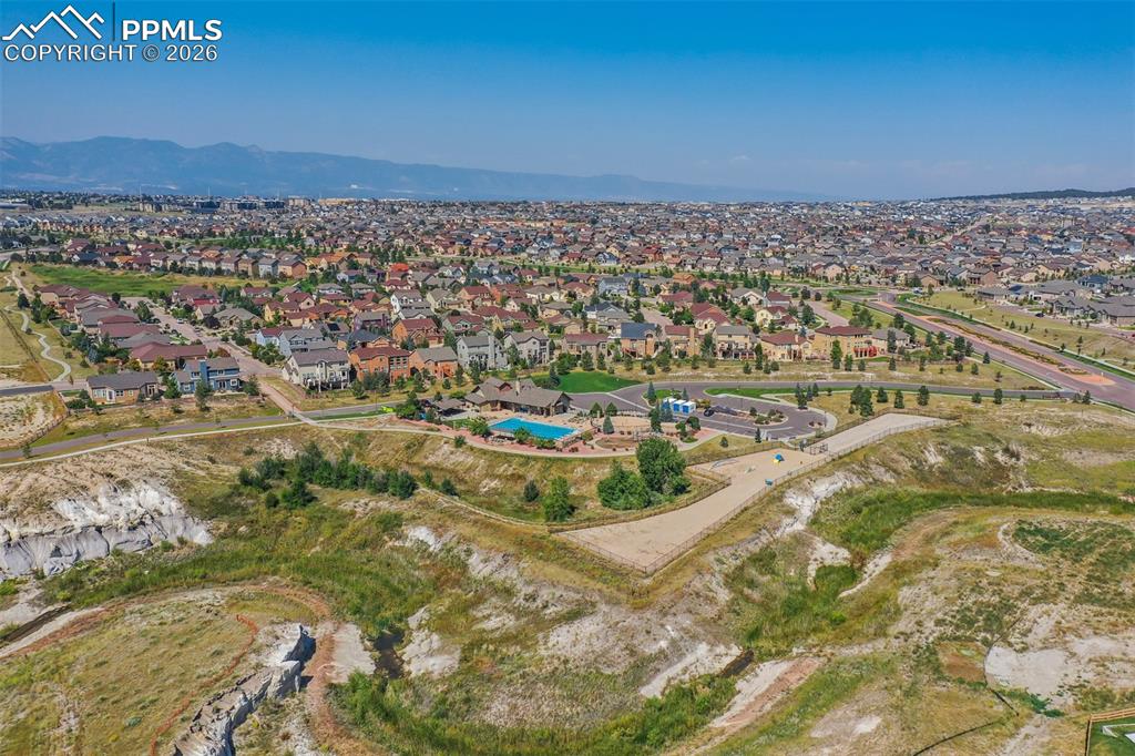 Image 40 of 46: Aerial view of residential area featuring a mountainous background