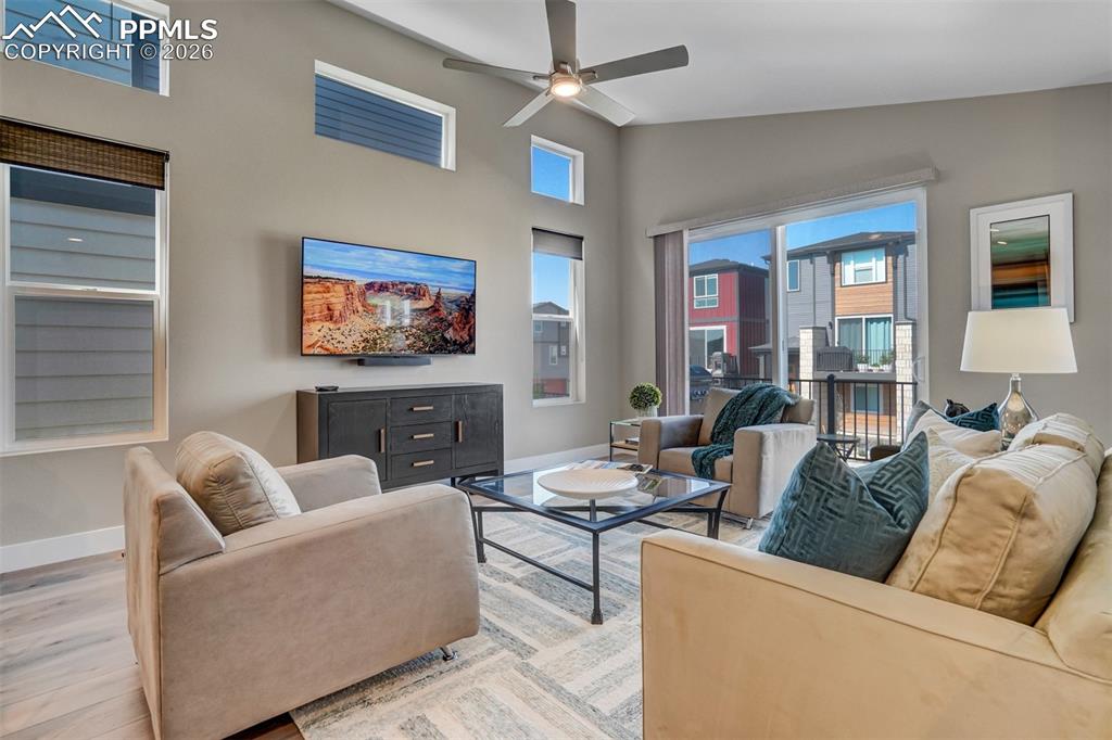 Image 9 of 46: Living room featuring a ceiling fan, wood finished floors, and lofted ceili