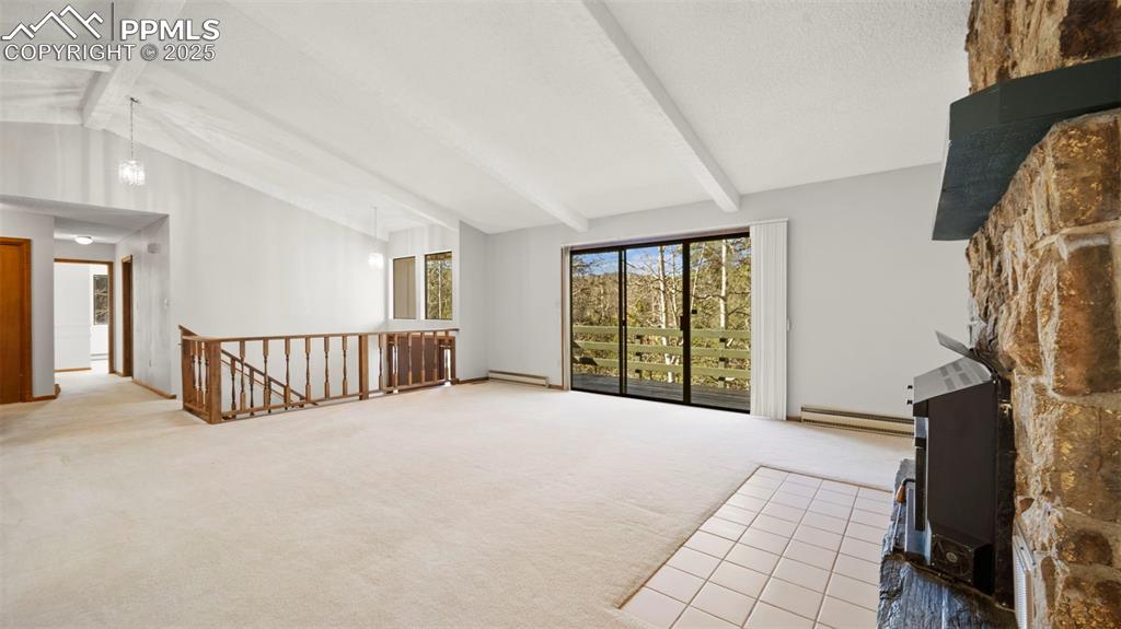 Image 11 of 50: Unfurnished living room featuring light carpet and a baseboard heating unit