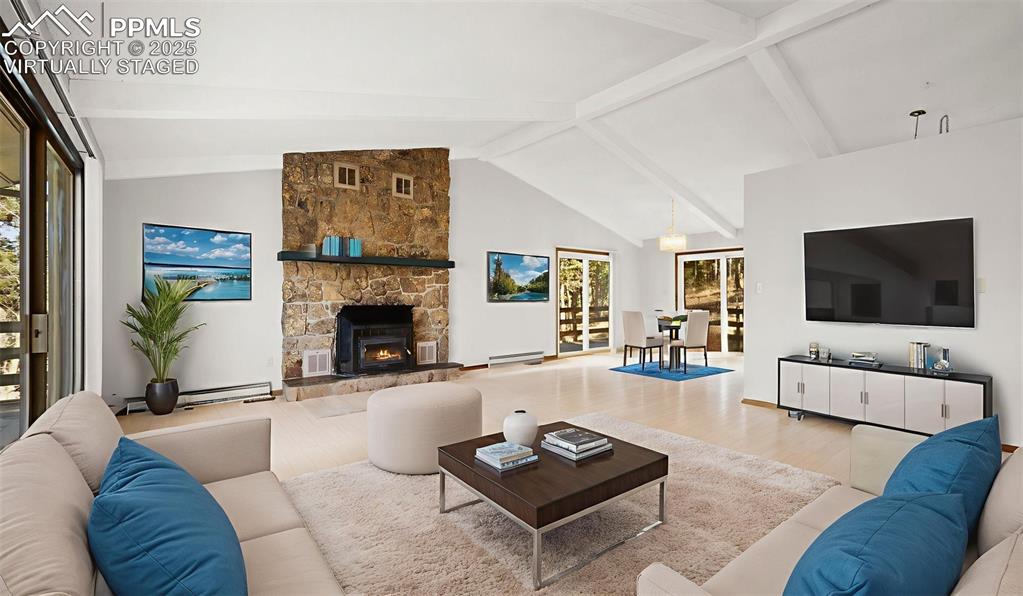 Image 12 of 50: Living area with wood finished floors, beam, ceiling, baseboard, heating, a