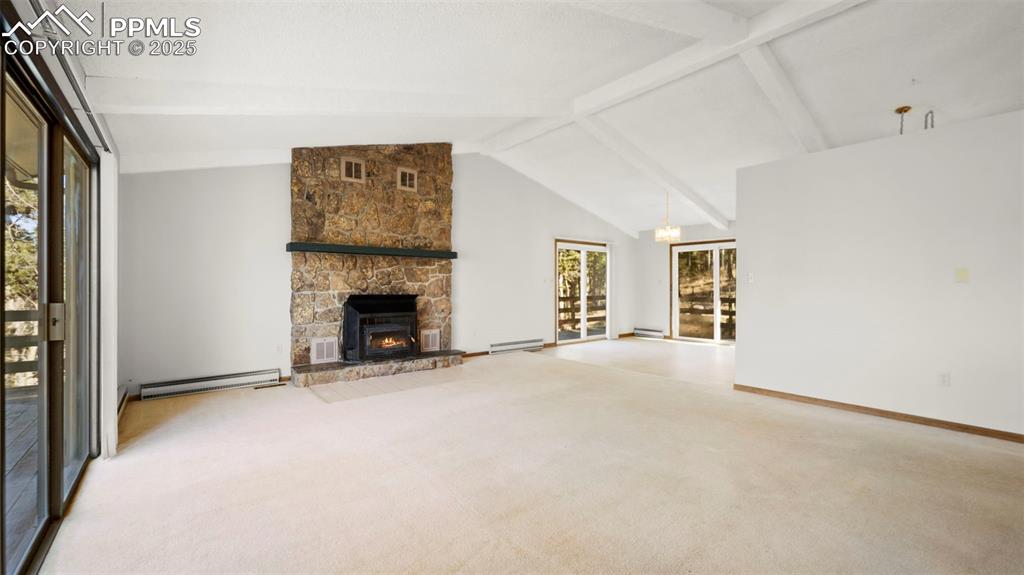 Image 13 of 50: Unfurnished living room featuring beamed ceiling, light carpet, baseboard h