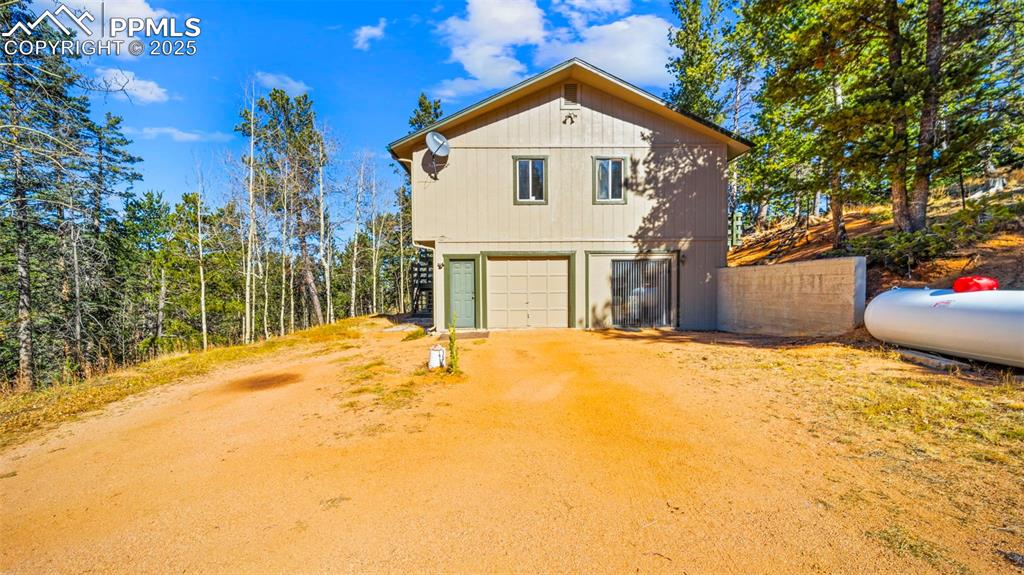 Image 30 of 50: View of front of property with dirt driveway and a garage