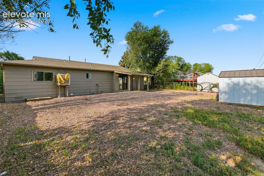 Image 10 of 36: Expansive outdoor space featuring a covered patio, gravel landscaping, a st