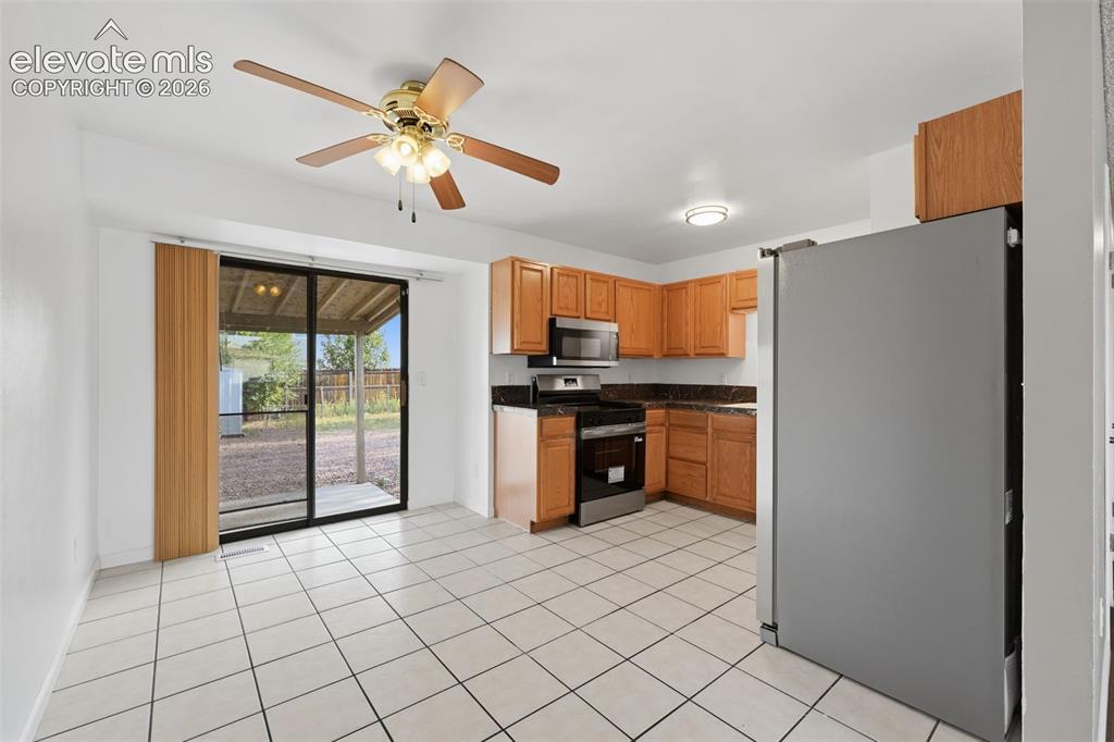 Image 19 of 36: Kitchen featuring wood cabinetry, stone-finish countertops, stainless steel