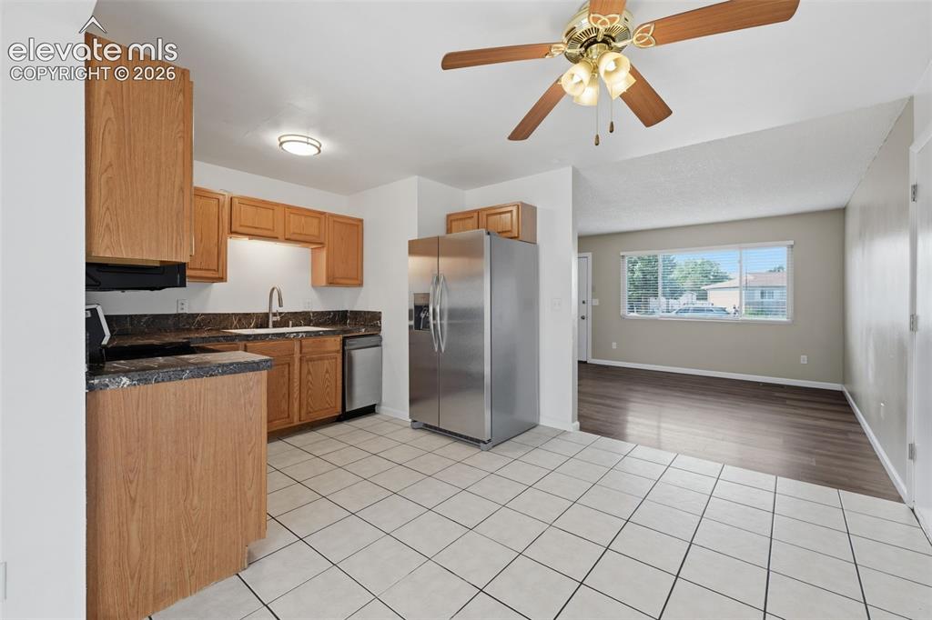 Image 20 of 36: U-shaped kitchen with wood-finish cabinetry, dark countertops, and stainles