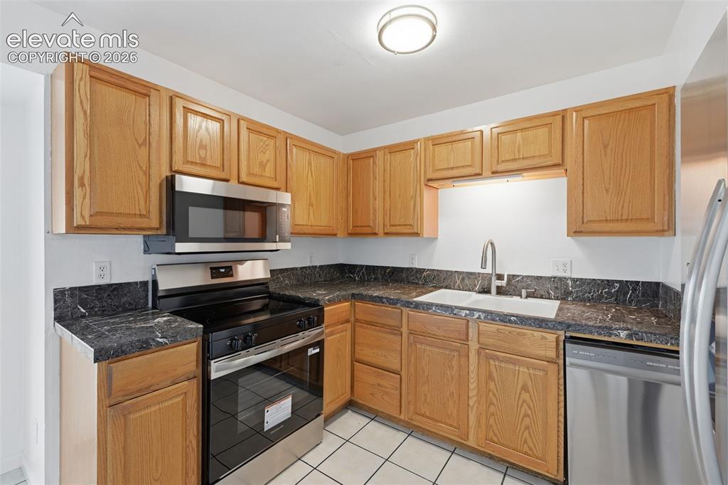 Image 22 of 36: Kitchen featuring wood cabinetry, a double basin sink with a gooseneck fauc