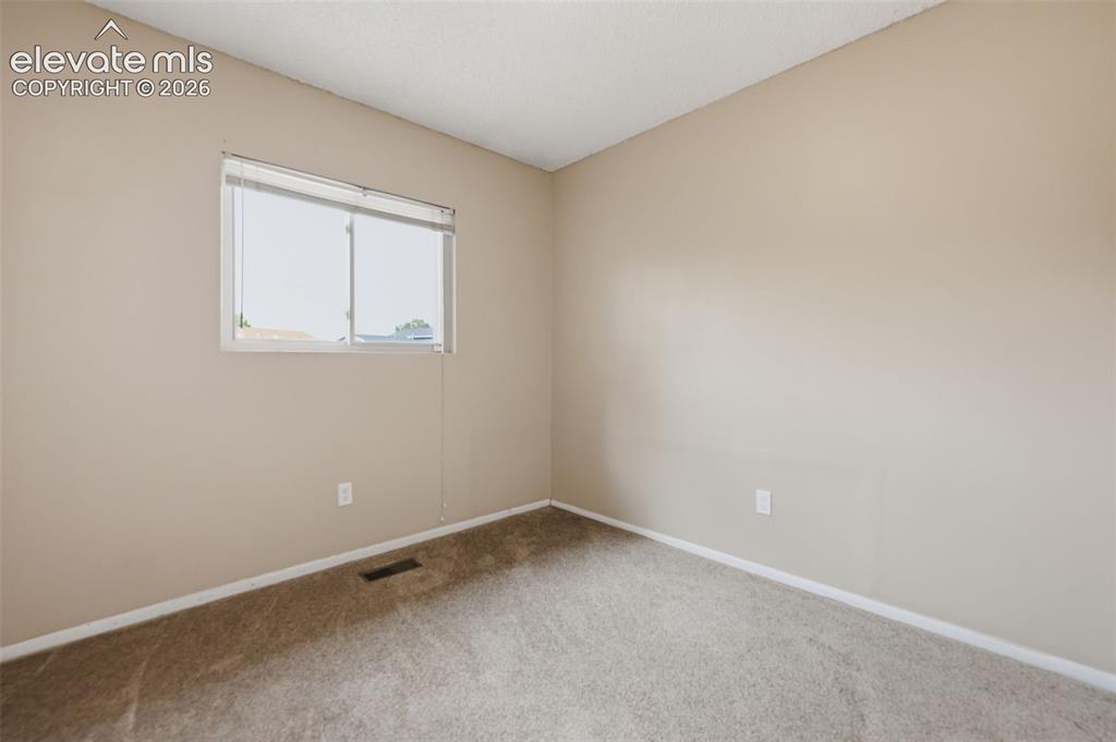 Image 32 of 36: Neutral tone wall paint, textured ceiling, and neutral tone carpeting