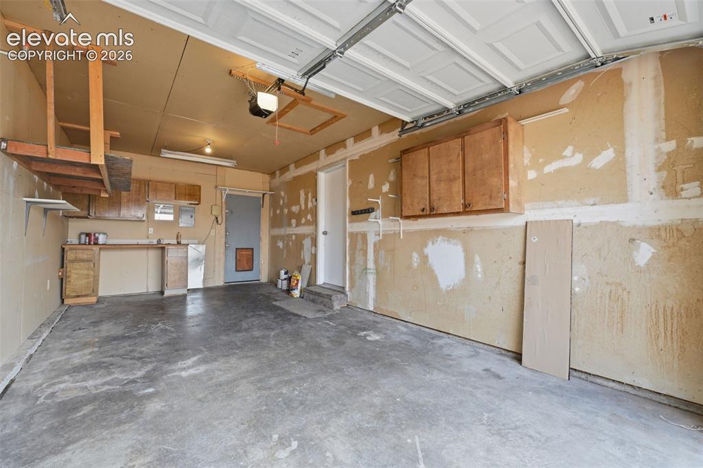 Image 36 of 36: White tile flooring, ceiling fan with light fixture, wood cabinetry, built-