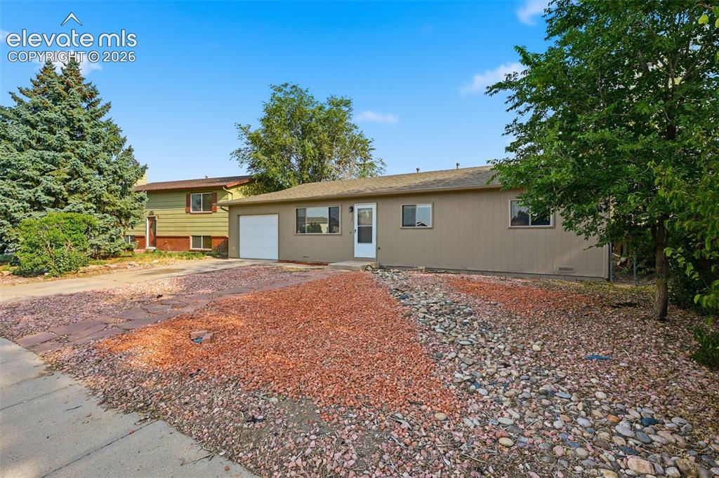 Image 5 of 36: Exterior featuring a single-car garage, multiple windows, and a landscaped 