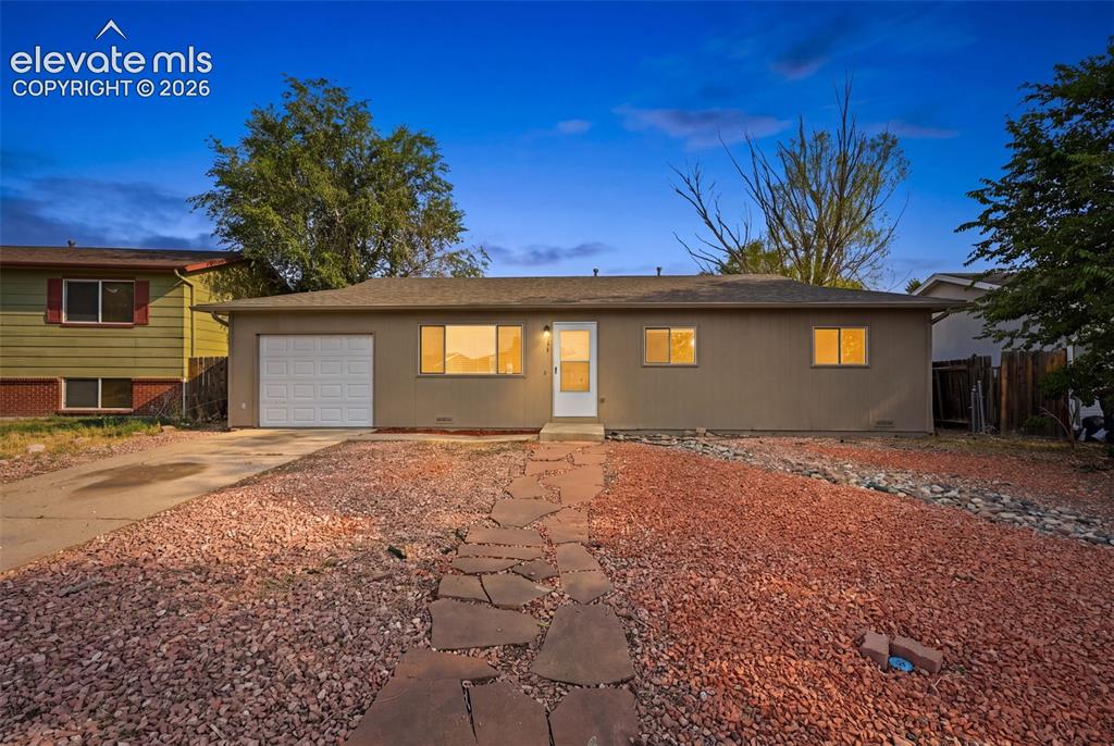 Image 7 of 36: Expansive backyard featuring a gravel surface, mature trees, and a covered 