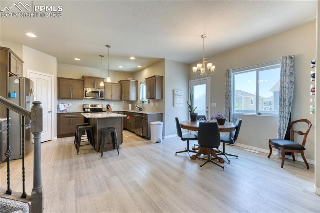 Image 10 of 39: Dining area with light wood-style flooring, a chandelier, and recessed ligh