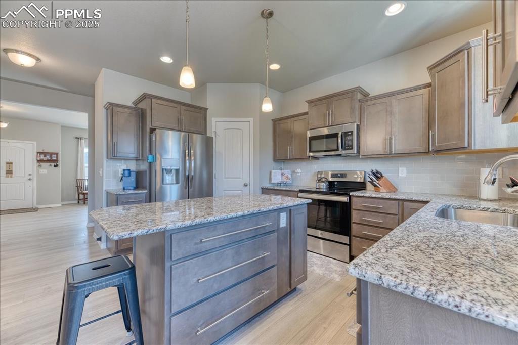 Image 11 of 39: Kitchen featuring appliances with stainless steel finishes, a kitchen islan