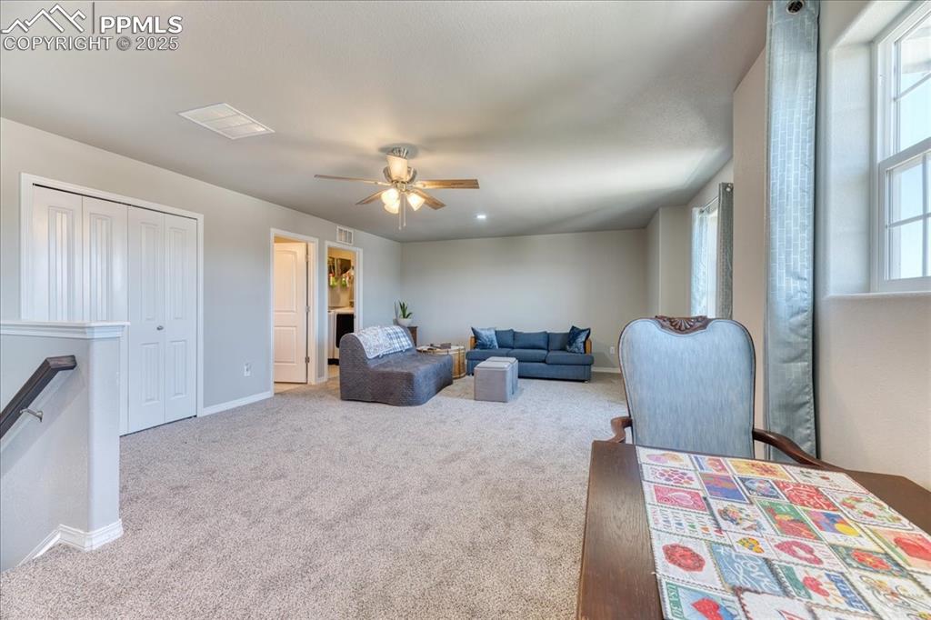 Image 16 of 39: Living area featuring carpet flooring and ceiling fan