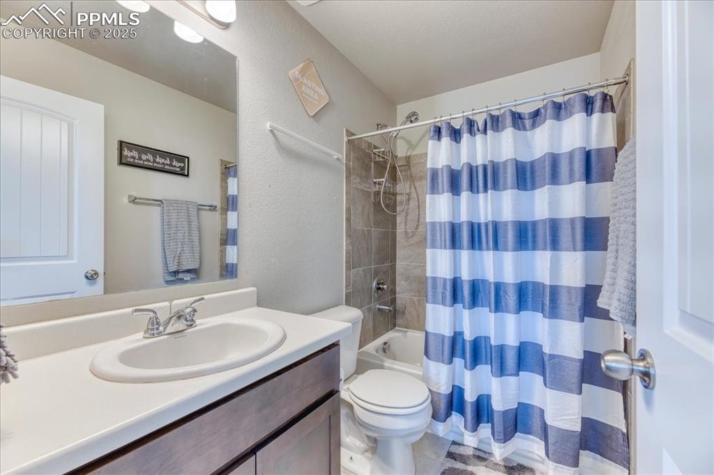 Image 18 of 39: Bathroom with vanity, shower / tub combo, and a textured wall