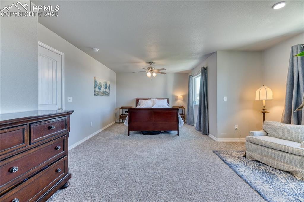 Image 21 of 39: Bedroom with light colored carpet and a ceiling fan