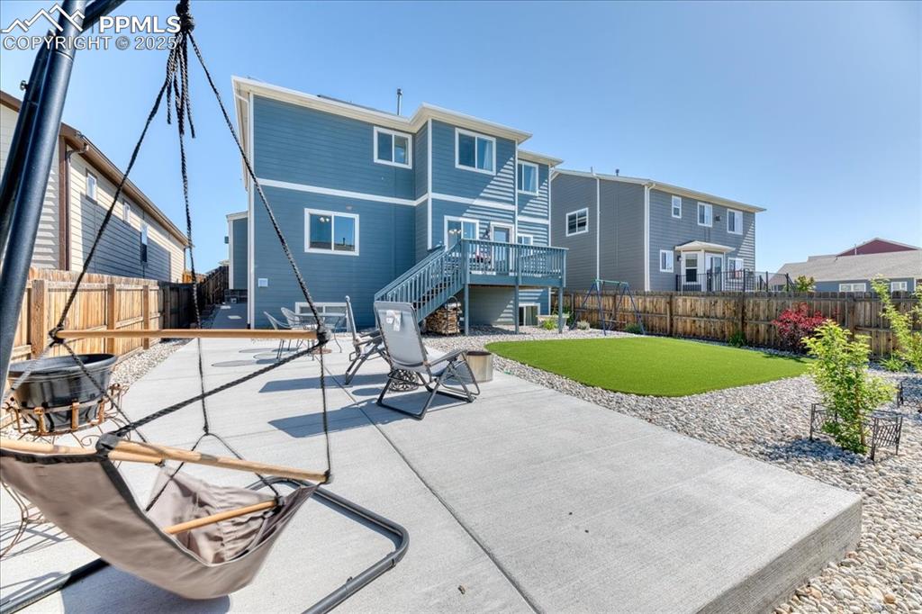 Image 38 of 39: Rear view of house featuring stairway, a fenced backyard, a patio, and a de