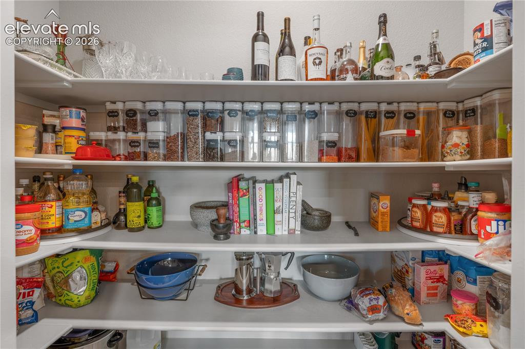 Image 12 of 38: Spacious pantry with multiple white shelves providing abundant storage