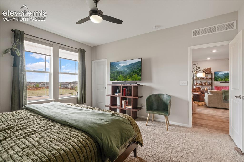 Image 22 of 38: Carpeted room featuring multiple windows, a ceiling fan with integrated lig
